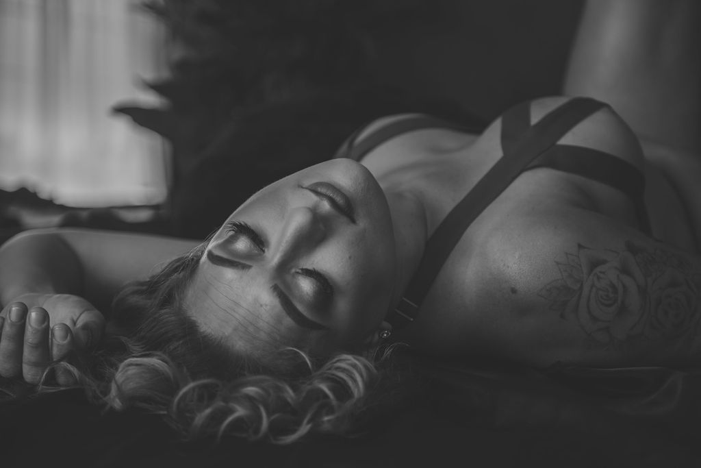 woman in cutout lingerie laying with her eyes closed