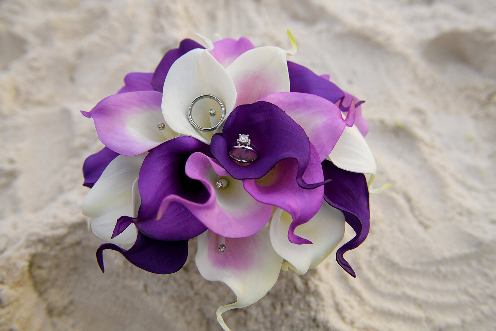 purple bouquet of flowers with wedding rings
